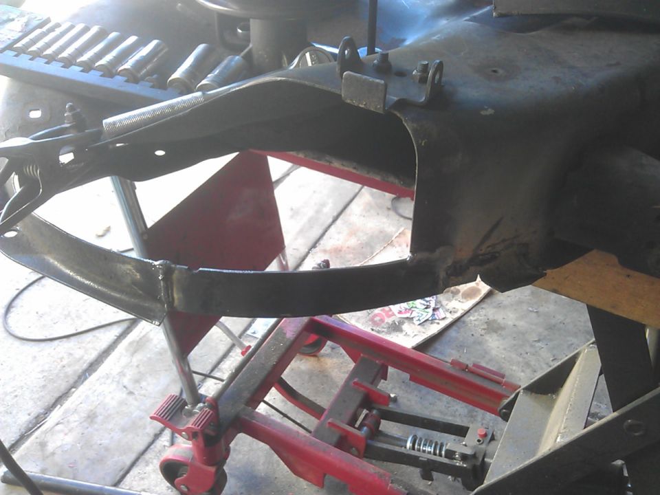 Close-up of a black metal frame with visible welds, possibly part of a vehicle.