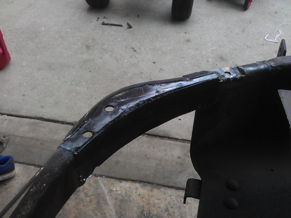 Black metal vehicle frame with welds and holes
