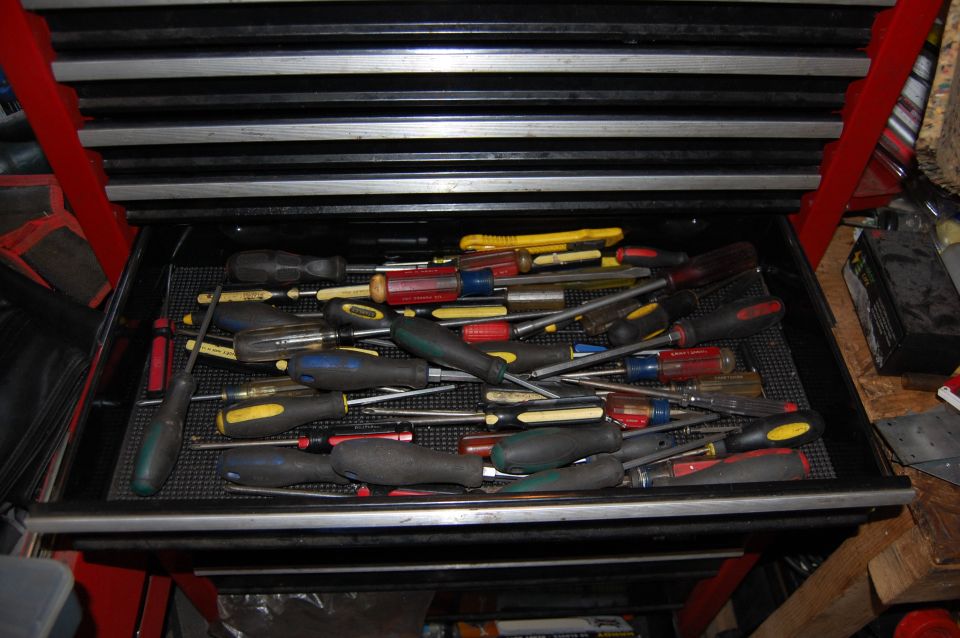 Drawer of screwdrivers and tools in a toolbox.