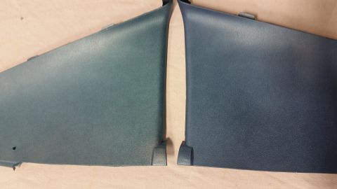 2015 Chevrolet new - Two dark blue plastic trim pieces are shown laid out on a light-colored surface. The pieces appear to be interior trim panels, possibly fro…