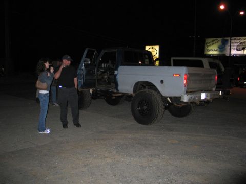 1995 Ford Bronco - A modified Ford truck is parked at night with its doors open.