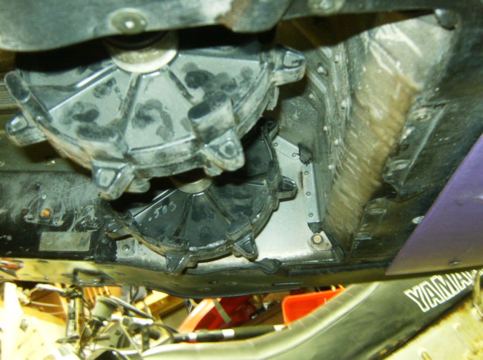 Underside of a snowmobile showing drive and driven clutch assemblies.