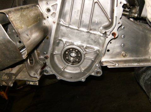 2000 Ford E350 - A close-up view of a vehicle's engine component, likely a transmission housing, with a visible bearing and metal bracing. The aluminum casi…