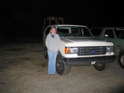 1995 Ford Bronco - Woman poses with a white 1992 Ford Bronco, with another truck visible to the right.