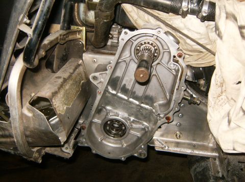2000 Ford E350 - A close-up view of the exposed drivetrain components of a vehicle, likely a snowmobile or ATV, showing a metal casing with a shaft and bear…