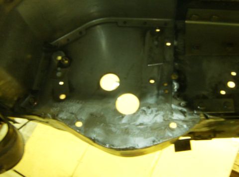 2000 Ford E350 - This is a close-up view of the firewall area of a vehicle, showing several circular cutouts and mounting points. The metal appears to be da…