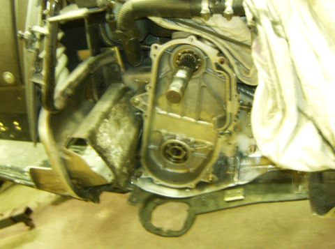 2000 Ford E350 - A close-up view of the engine compartment of a Ford E350, showing the transmission housing and internal gears. The engine appears to be und…