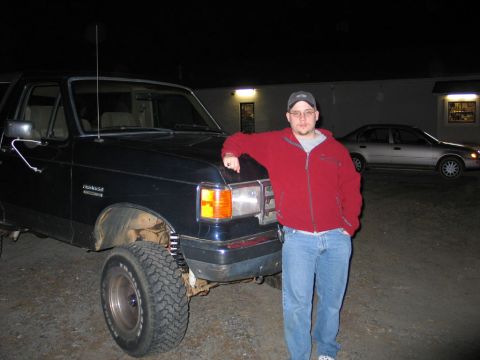 1995 Ford Bronco - A man stands next to a Ford Bronco at night, with another car visible in the background.