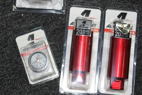2003 Ford Crown Victoria - New Aeromotive fuel system parts, including a gauge and two red components, are displayed in their packaging.