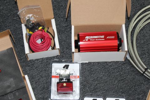 2003 Ford Crown Victoria - red Aeromotive A1000 fuel pump boxed alongside coiled red wire, braided stainless line, and a blister-packed red regulator.