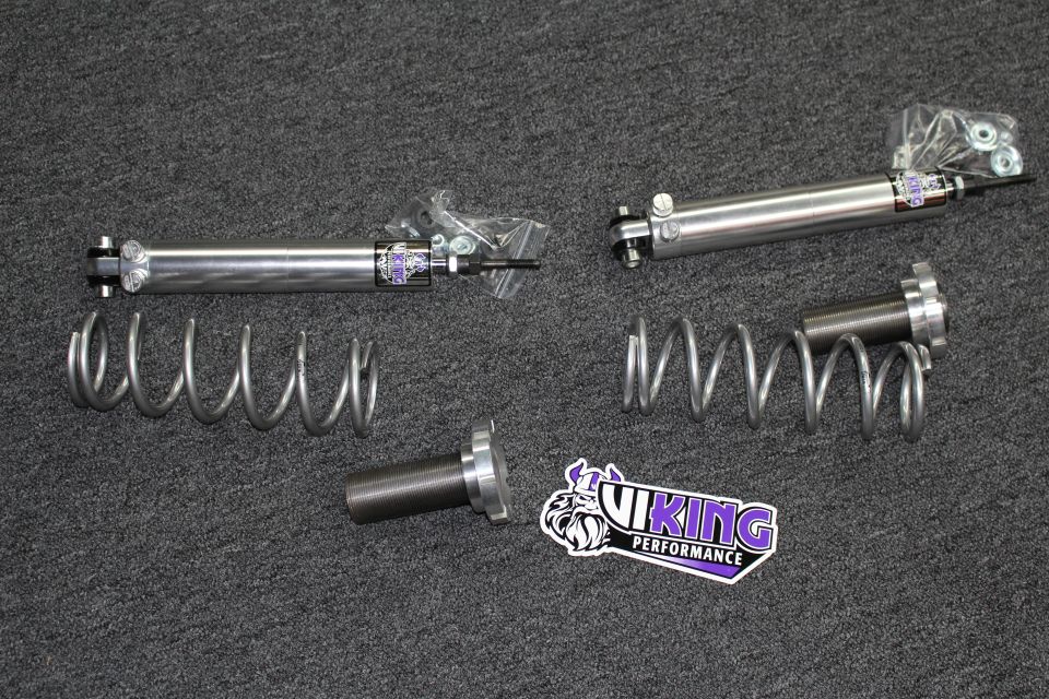 Two Viking shock absorbers, two coil springs, and a threaded sleeve with Viking Performance decal on carpet