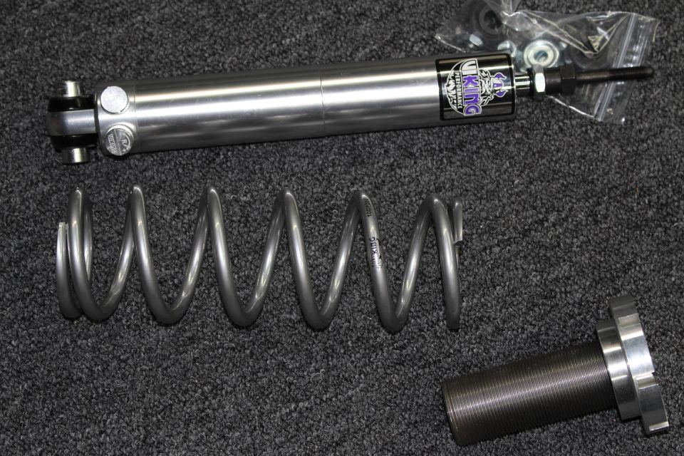 Single Viking shock absorber, one coil spring, and a threaded billet sleeve on dark gray carpet