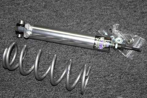 2003 Ford Crown Victoria - polished Viking shock absorber with bagged mounting hardware lying beside a coil spring on dark gray carpet.