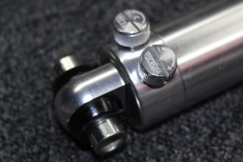 2003 Ford Crown Victoria - Detail of a chrome coilover shock body with twin Viking compression and rebound adjustment knobs near the lower bushing mount.