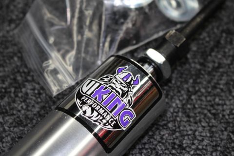 2003 Ford Crown Victoria - Close-up of a coilover shock showing the purple-and-black Viking Performance viking-head logo decal on the polished body.