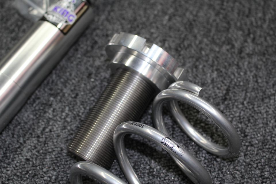 Threaded coilover shock body, spanner-nut perch, and coiled silver suspension springs