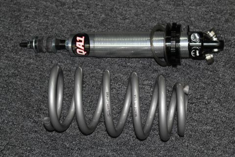 2003 Ford Crown Victoria - QA1-branded coilover shock absorber displayed above a gray coil spring stamped QA110HTSF450, Made in USA.
