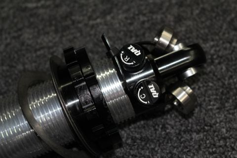 2003 Ford Crown Victoria - Close-up of a black-anodized coilover upper assembly with two QA1 rebound and compression adjustment knobs and machined fittings.