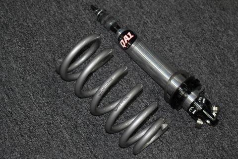 2003 Ford Crown Victoria - complete QA1 coilover assembly with its gray coil spring stamped QA110HTSF450 laid out on dark carpet.
