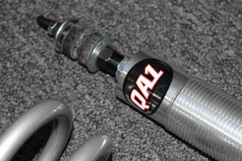 2003 Ford Crown Victoria - Detail of a threaded coilover shock shaft and body bearing the red-and-black QA1 brand decal.