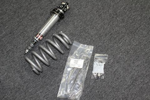 2003 Ford Crown Victoria - QA1 coilover shock with gray coil spring displayed alongside two bags of mounting hardware on gray carpet.