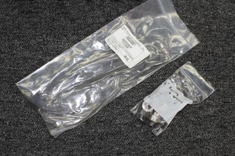 2003 Ford Crown Victoria - Two sealed clear plastic bags holding metal coilover hardware and spanner components with printed and handwritten labels.