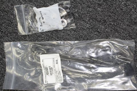 2003 Ford Crown Victoria - Two bags of coilover hardware on carpet, the larger labeled QA1 Precision Products and the smaller handwritten with bearing notes.