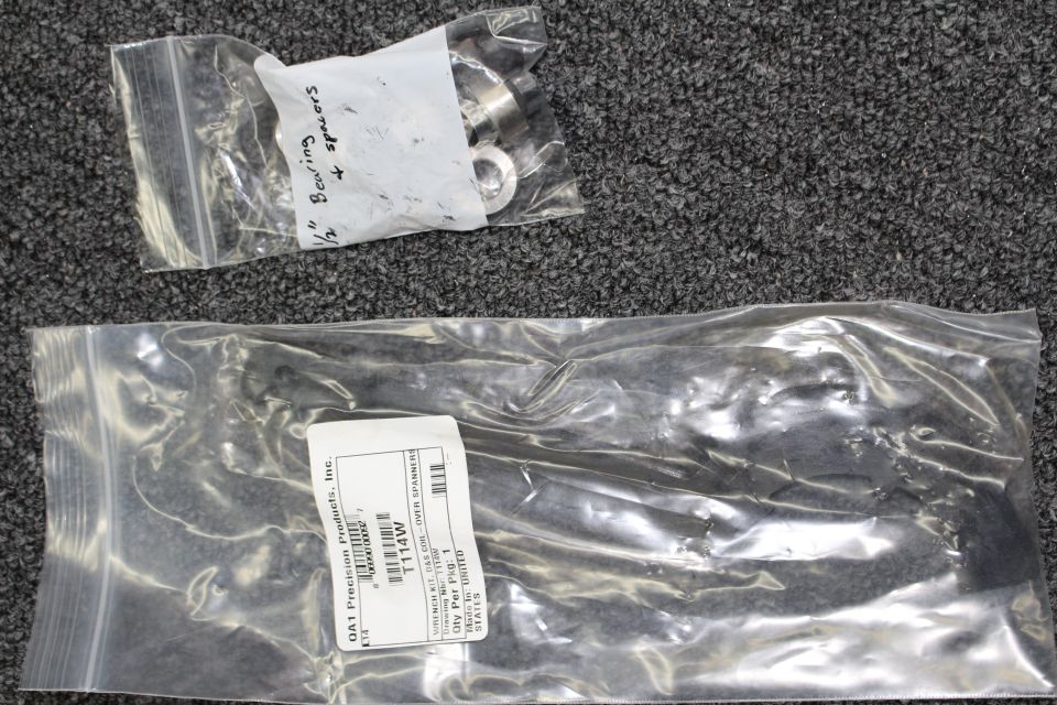 Two bagged hardware packets, one labeled QA1 Precision Products with part T114W