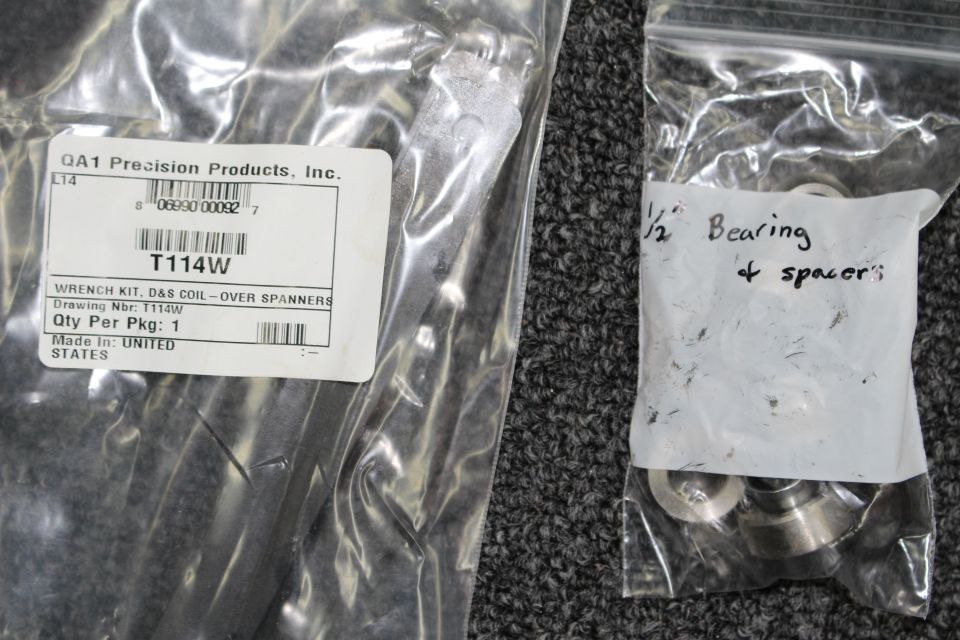 QA1 spanner wrench kit bag beside handwritten bag labeled bearing and spacers