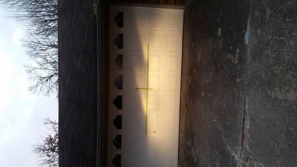 White garage door with a yellow tape line across it