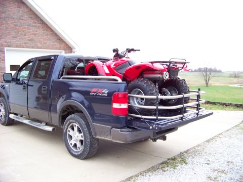1984 Honda ATC 250 R - A red ATV is transported in the bed of a blue pickup truck.
