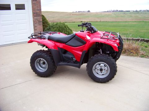 1984 Honda ATC 250 R - A red Honda all-terrain vehicle is parked on a concrete driveway in front of a garage.