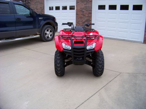 1984 Honda ATC 250 R - A red ATV is parked in front of a garage, with a blue pickup truck to its left.