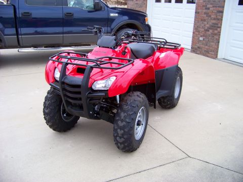 1984 Honda ATC 250 R - Red ATV parked on concrete, with a blue pickup truck and garage in the background.
