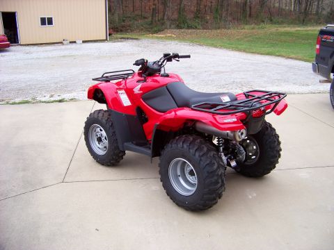 1984 Honda ATC 250 R - A red all-terrain vehicle is parked on a concrete surface in front of a building.