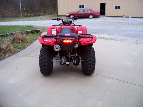 1984 Honda ATC 250 R - A red ATV is parked on a concrete driveway, with a red sedan visible in the background.