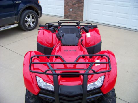 1984 Honda ATC 250 R - A red ATV is parked in front of a garage, with a blue truck to its left.