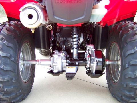 1984 Honda ATC 250 R - Close-up view of the rear axle and suspension components on a red all-terrain vehicle.