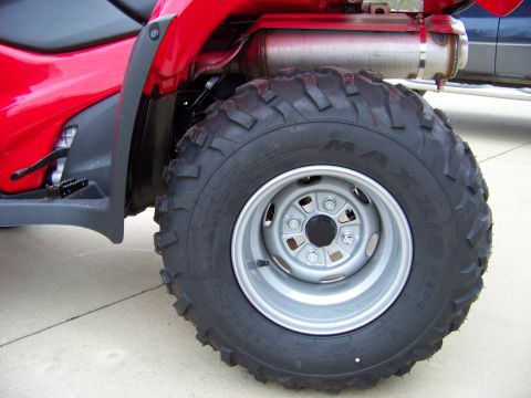 1984 Honda ATC 250 R - The rear wheel and exhaust system of a red ATV are shown in detail.