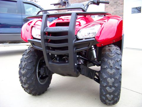 1984 Honda ATC 250 R - A red ATV is parked in front of a blue pickup truck and a garage door.