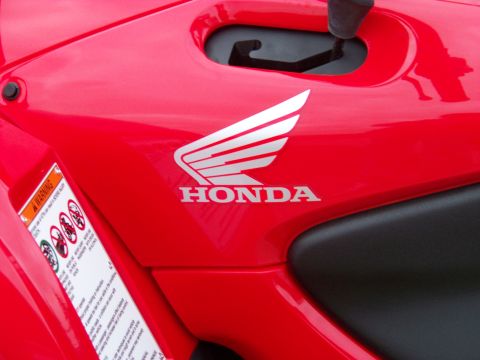 1984 Honda ATC 250 R - Close-up of a red Honda ATV's bodywork, showing the brand's wing logo and a safety warning label.