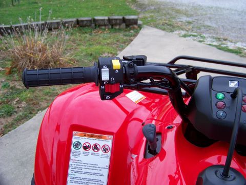 1984 Honda ATC 250 R - Close-up view of the handlebars and controls on a red ATV, a prominent warning label.