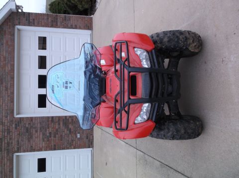 1984 Honda ATC 250 R - Red ATV with a clear windshield and graphics parked in front of a garage.