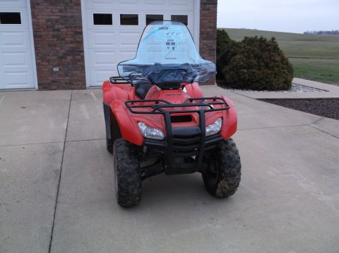 1984 Honda ATC 250 R - A red ATV with a clear windshield is parked on a concrete driveway in front of a brick garage.