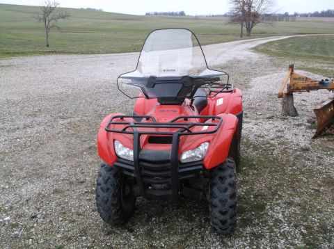 1984 Honda ATC 250 R - A red ATV is parked on a gravel surface in front of a field.