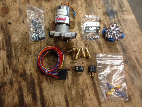 1979 Ford Bronco - A collection of automotive fuel system components, including a Summit Racing fuel pump and a chrome fuel pressure regulator, are displayed.