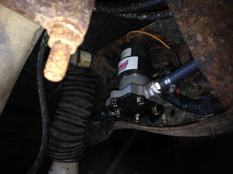 1979 Ford Bronco - Close-up of an aftermarket fuel pump assembly mounted to the vehicle's frame.