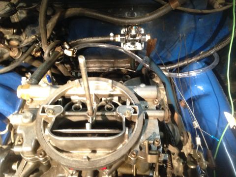 1979 Ford Bronco - This image shows a close-up view of a vehicle's carburetor and an aftermarket fuel pressure regulator.