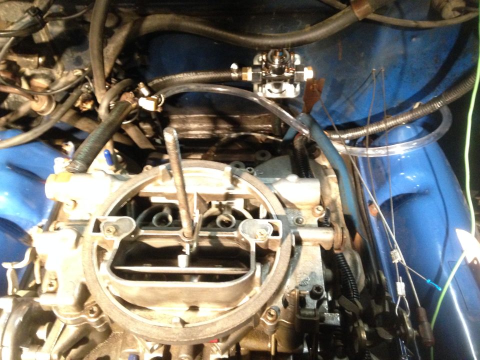 Engine bay with carburetor and fuel pump, close-up view