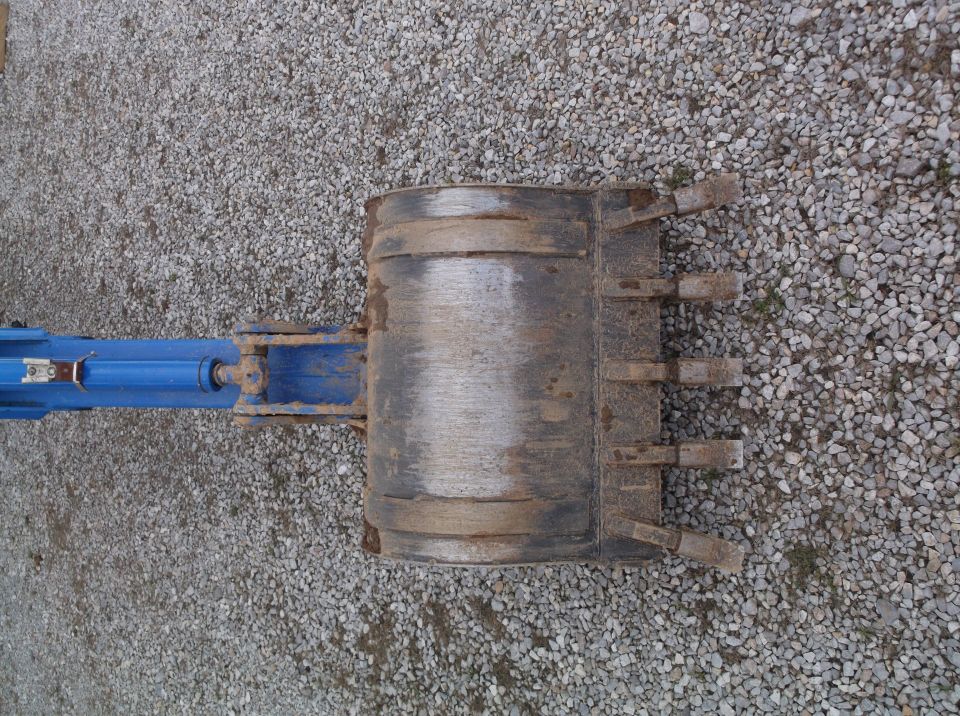 Backhoe attachment with blue hydraulic cylinder and metal bucket with teeth